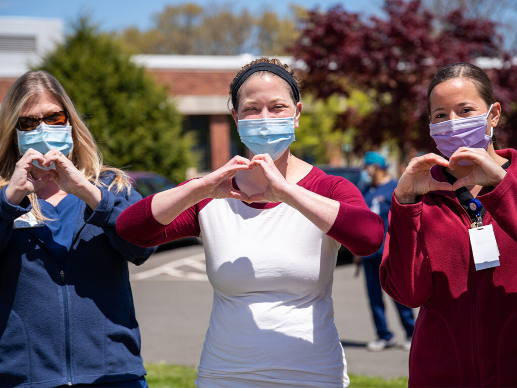 three nurses making heart shapes with hands