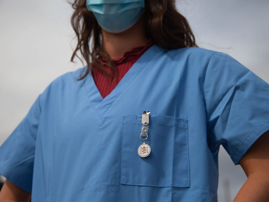 A closeup of a nurse with a badge clip
