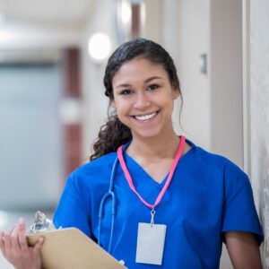 Young female nurse smiling while holding a clipboard