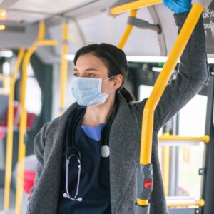 Nurse wearing a mask while riding a bus