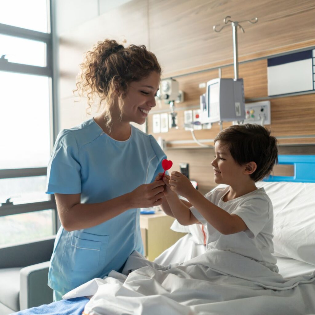 Pediatric nurse handing a child a lollipop.