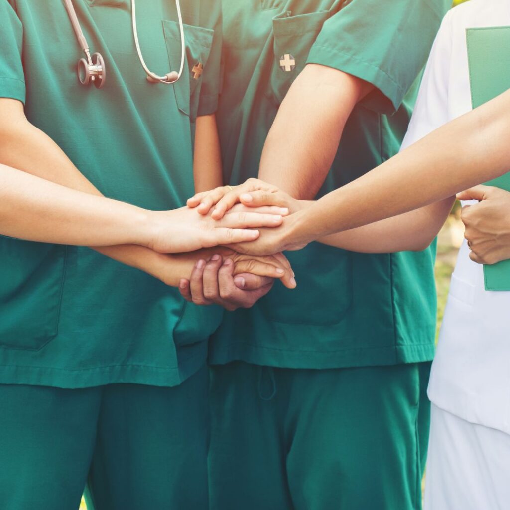 Nurses all touching hands