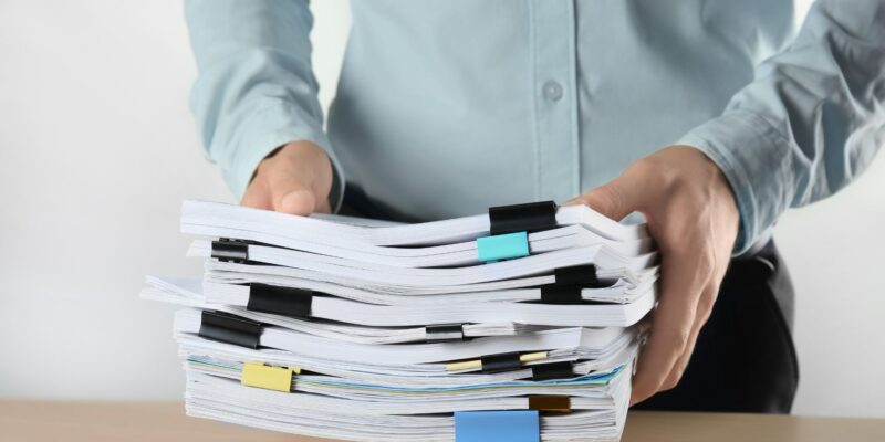 a man holding a stack of documents