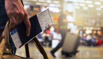 A person holding their boarding pass in an airport