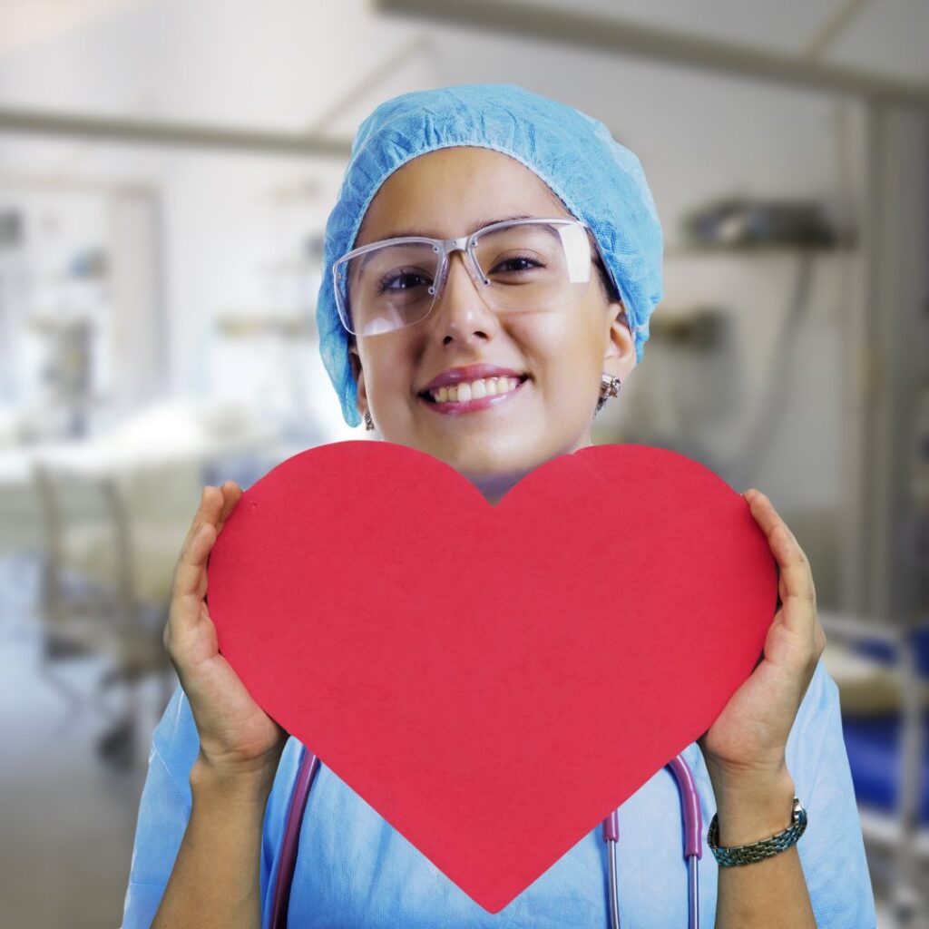 nurse holding up a cut out of a heart